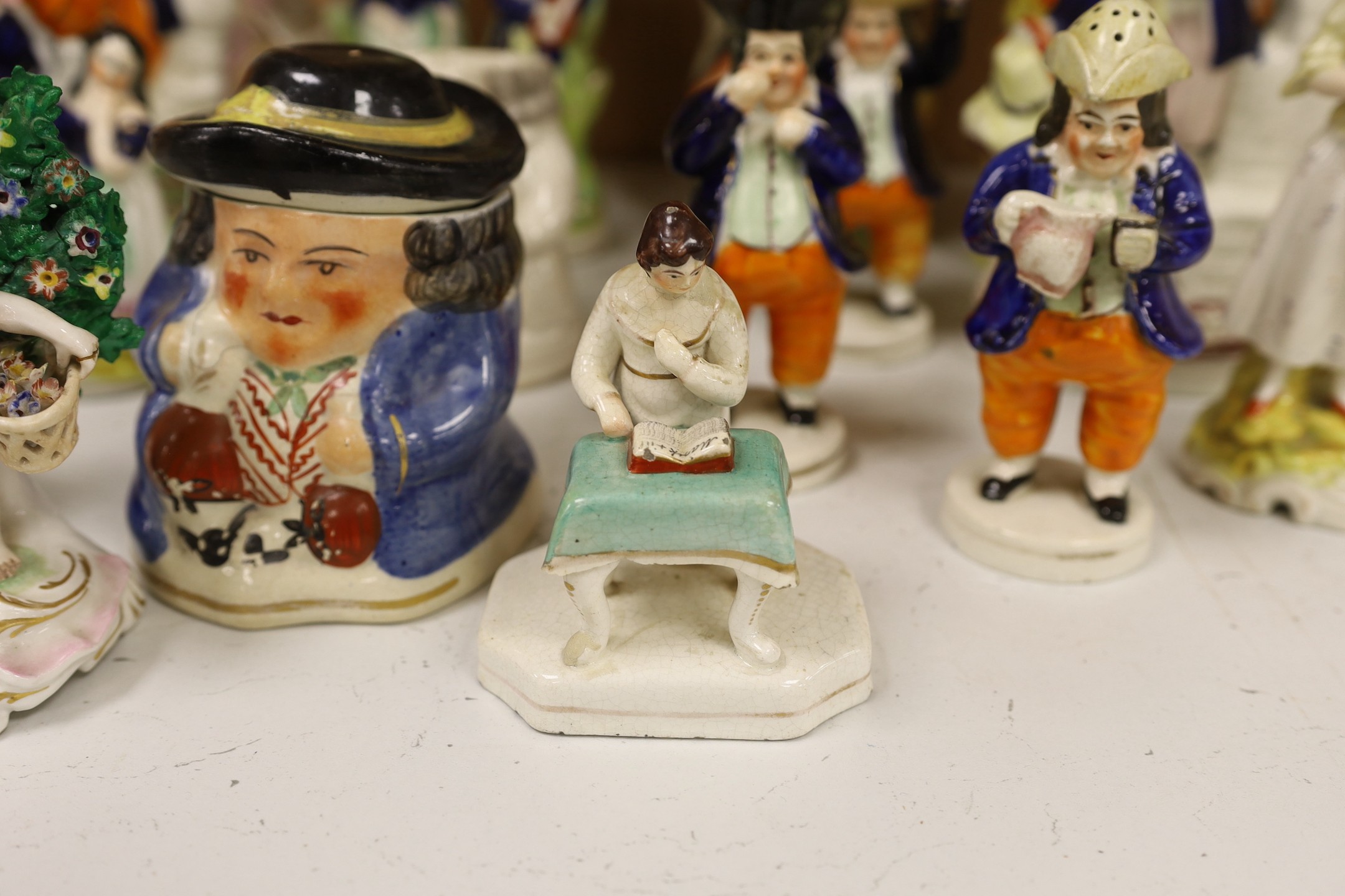 A large group of Staffordshire pottery figures and groups and figural cruets, to include a Nelson commemorative Toby jug, 31 cms high.